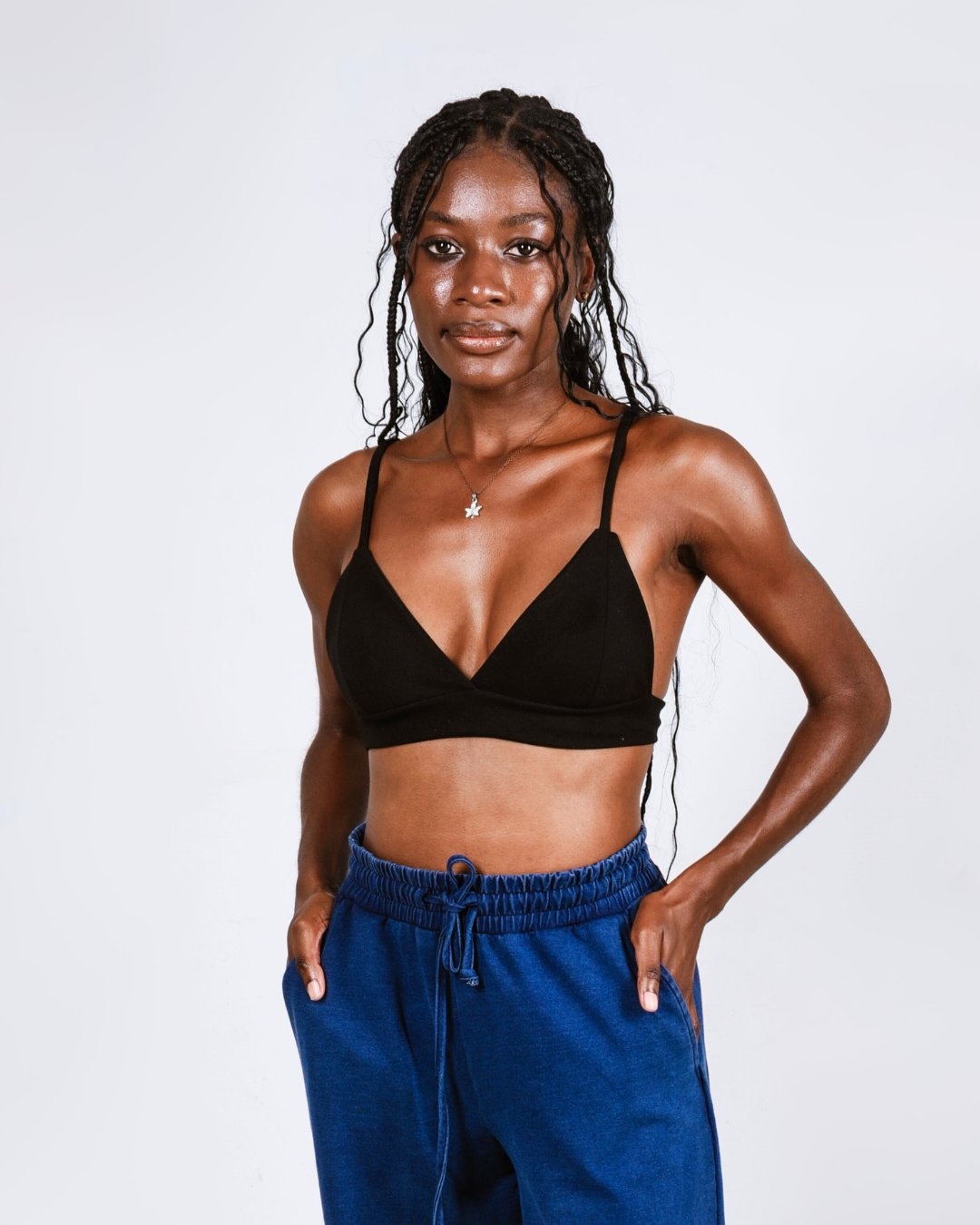Woman wearing a black bralette against a white background