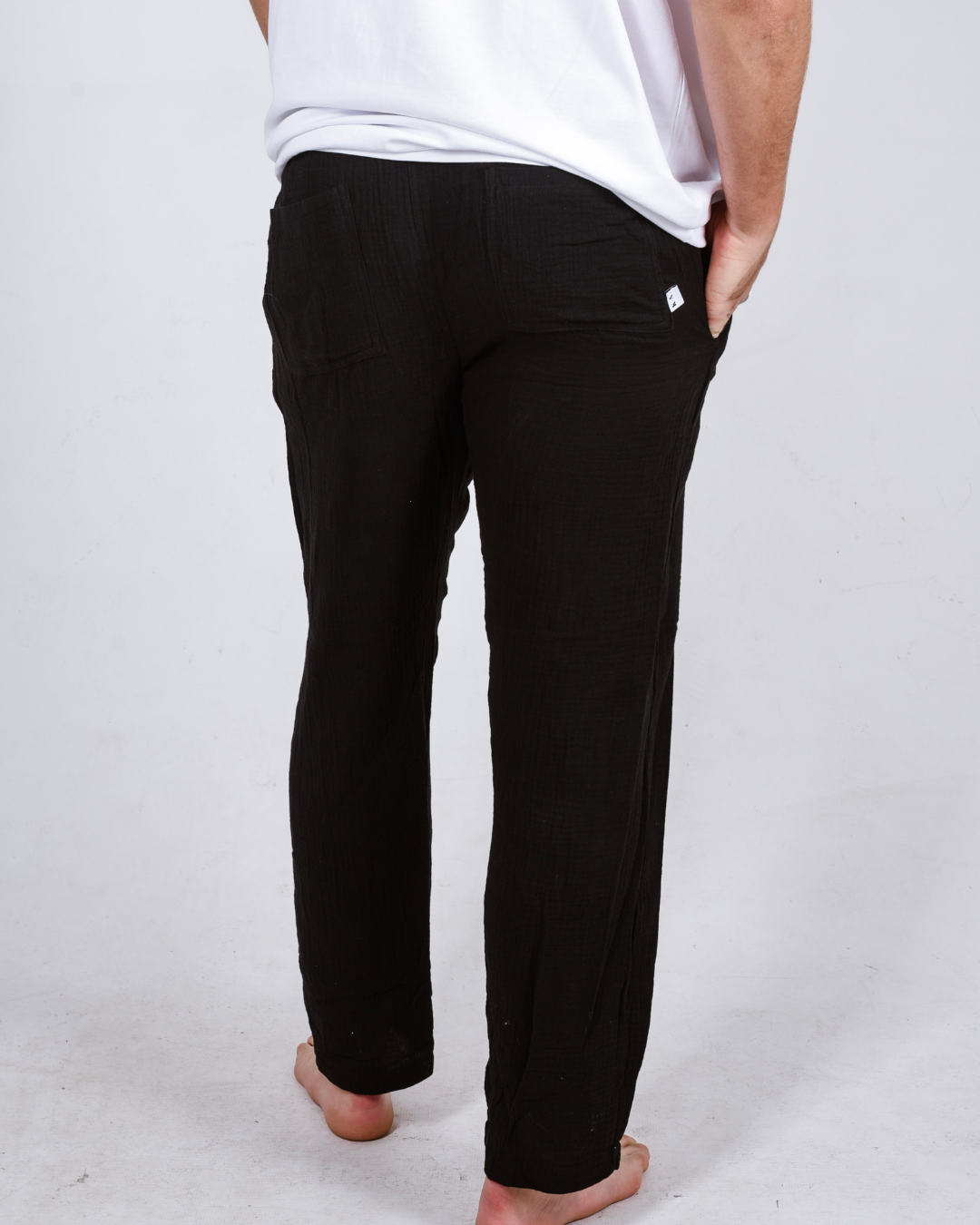 Male black cotton pants with a white shirt- back view