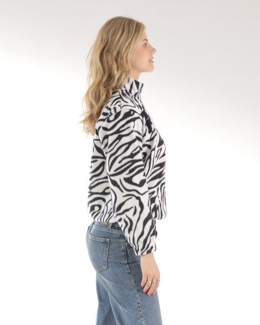 Side view of a female wearing the zebra print retro quarter zip jersey