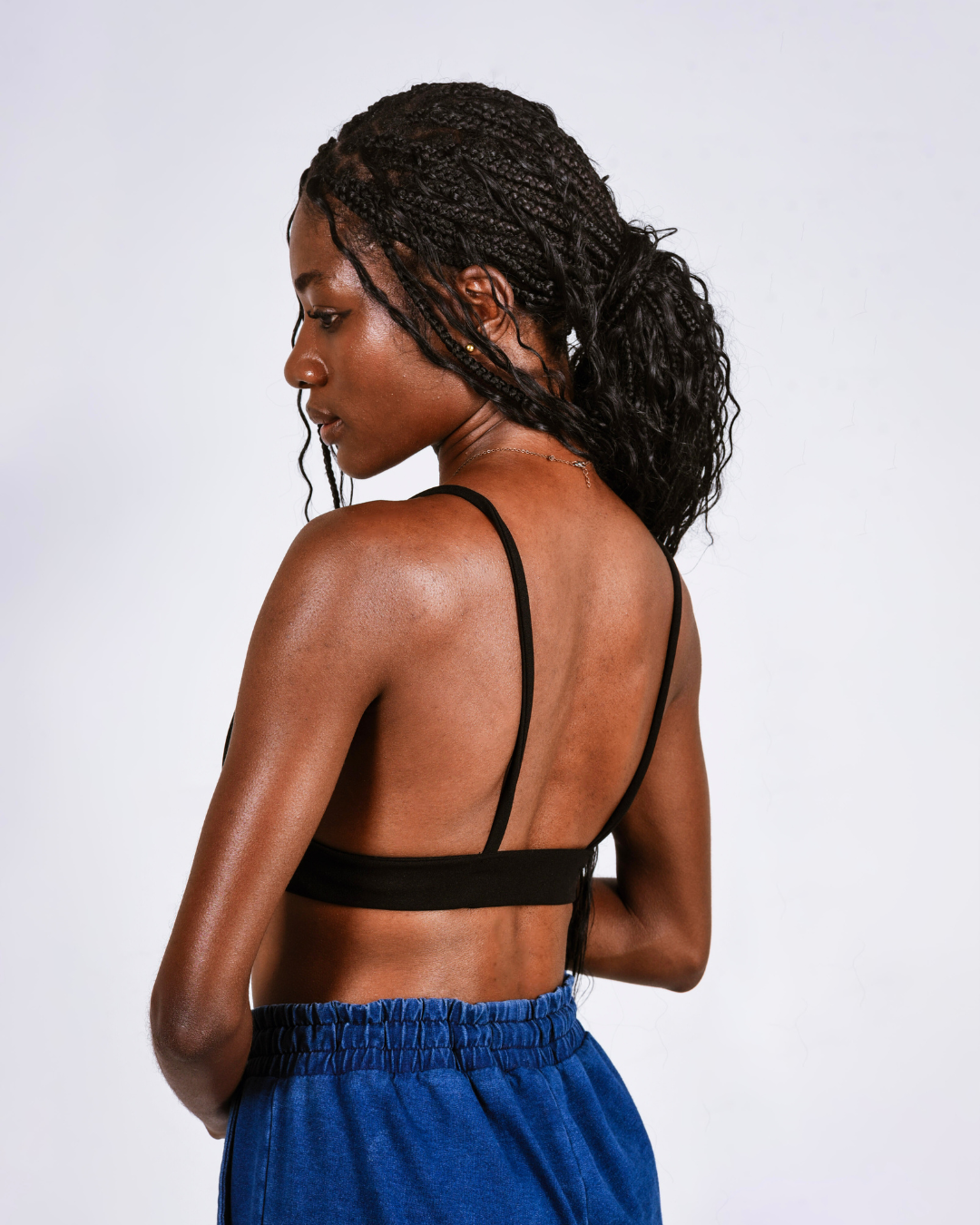 Woman wearing a black bralette against a white background