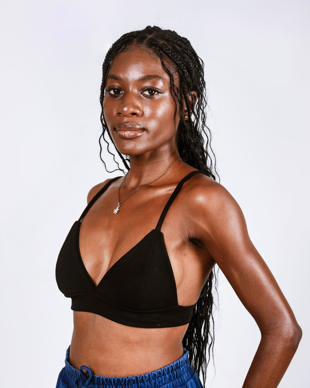 Woman wearing a black bralette against a white background