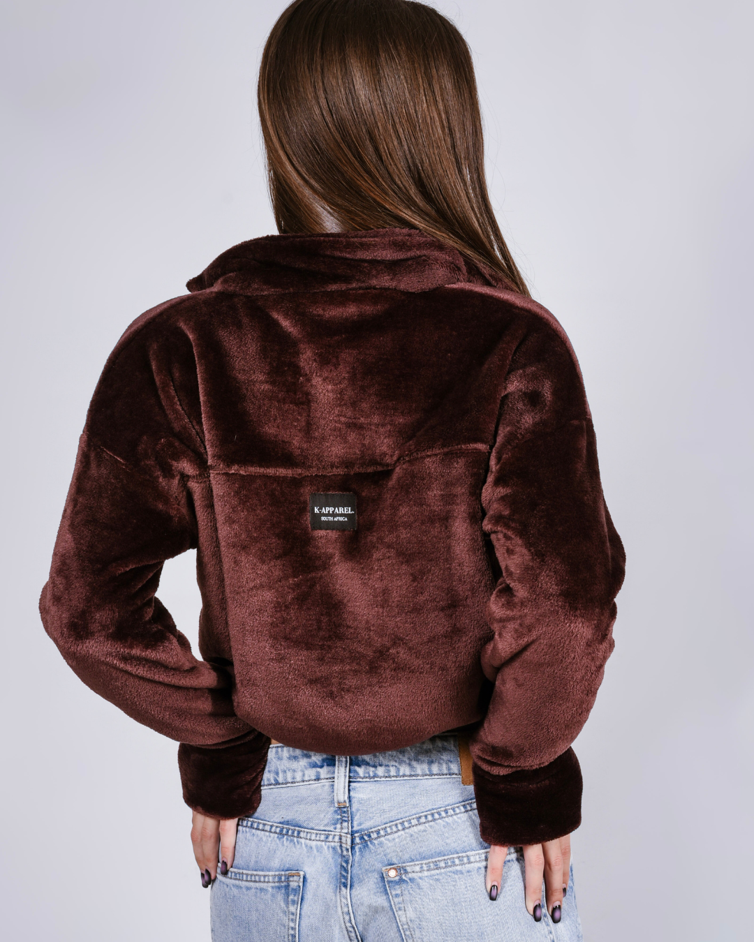 woman wearing a brown fluffy jacket with draw cords and thumb holes