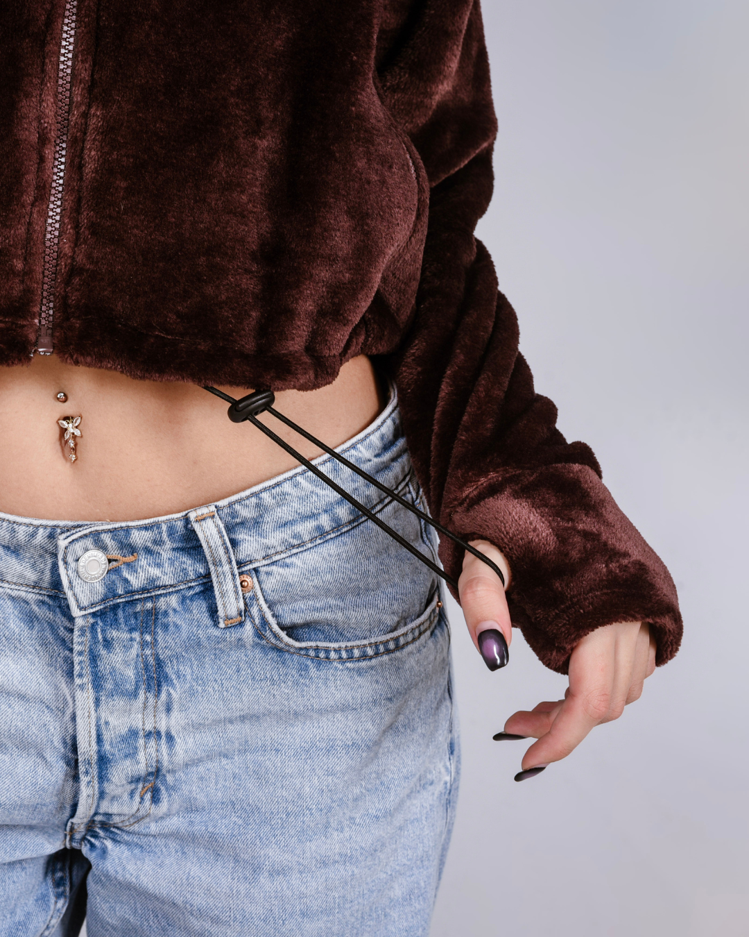 woman wearing a brown fluffy jacket with draw cords and thumb holes