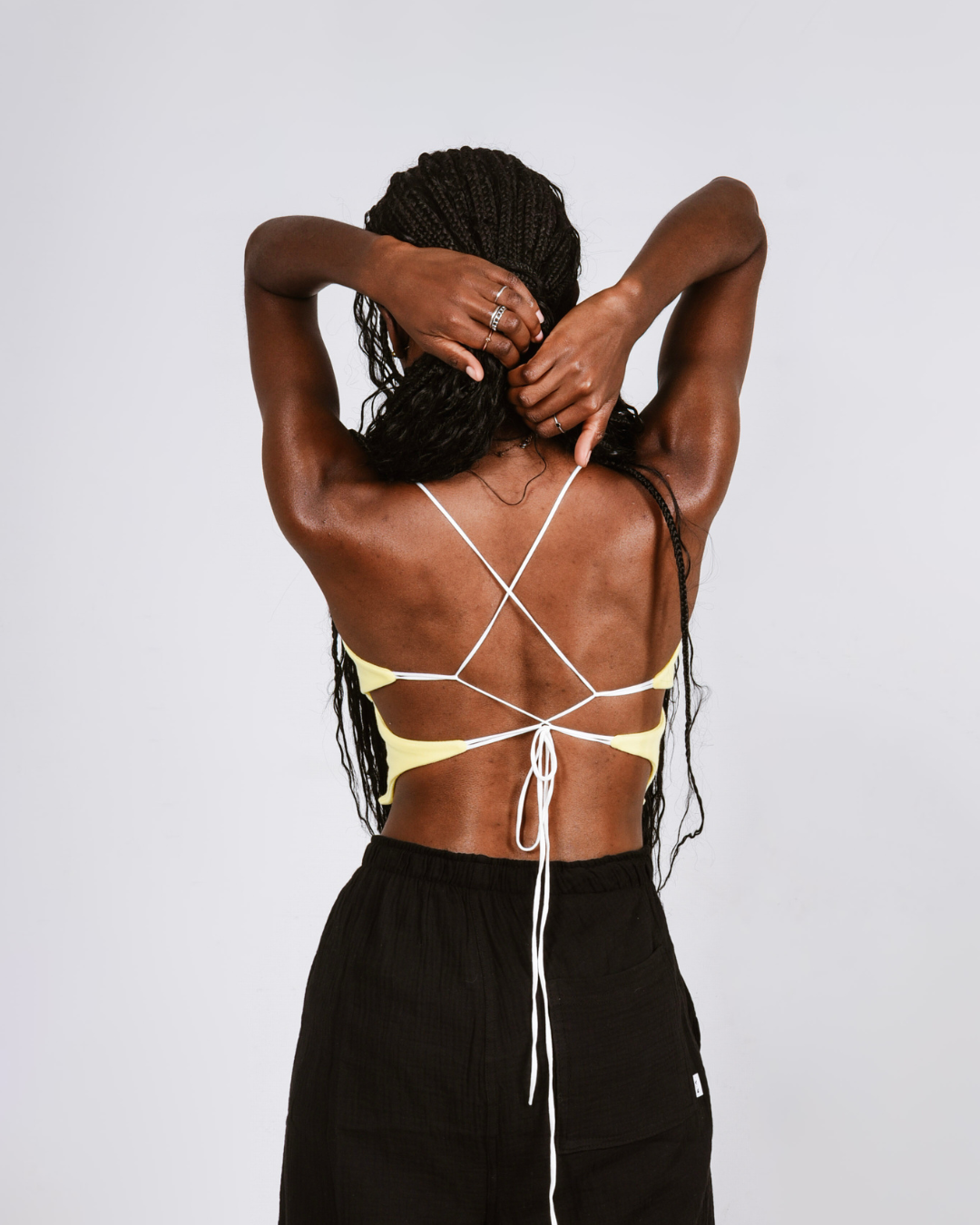 Woman wearing a yellow butterfly shaped top that ties at the back
