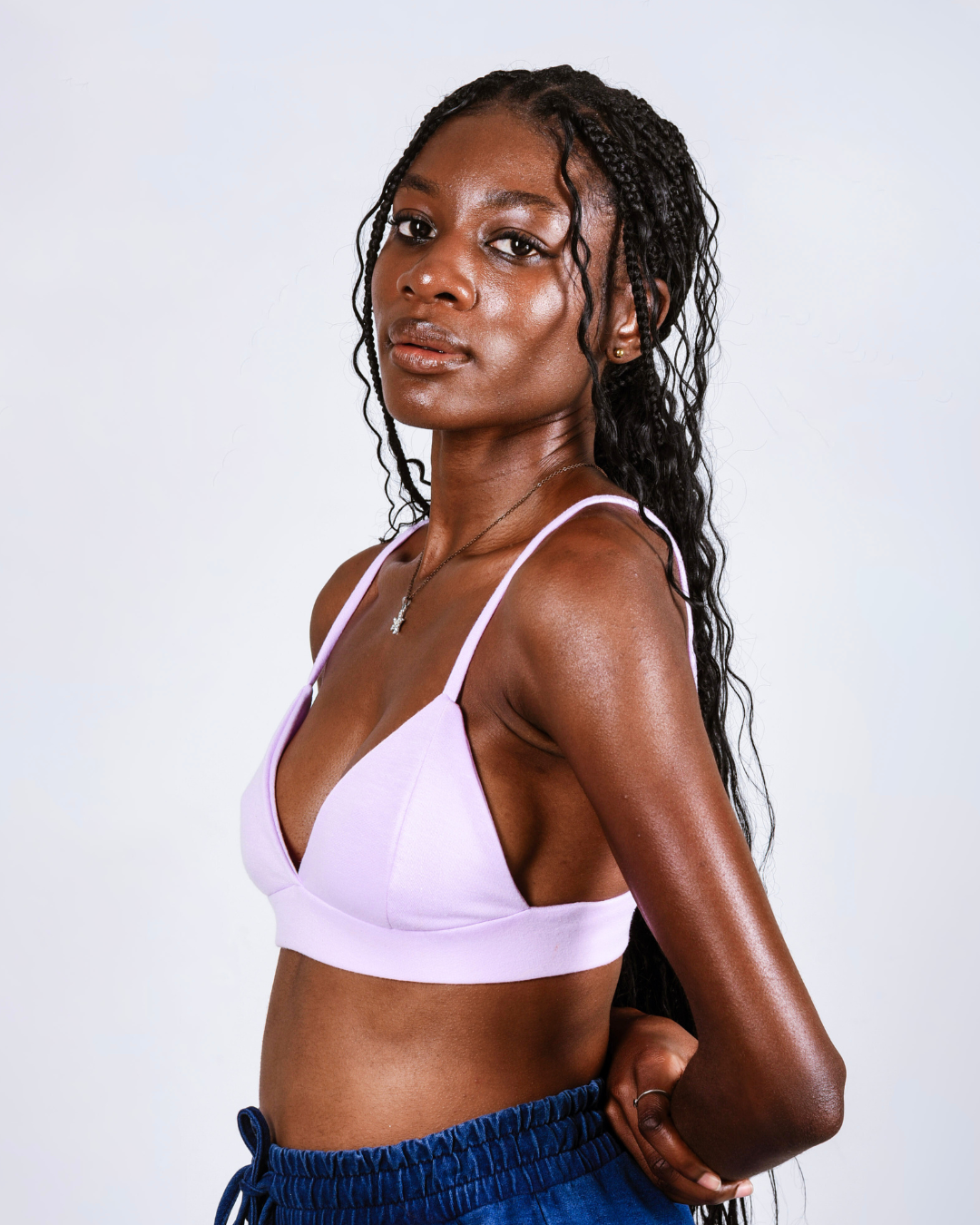 Woman wearing a light purple bralette against a white background