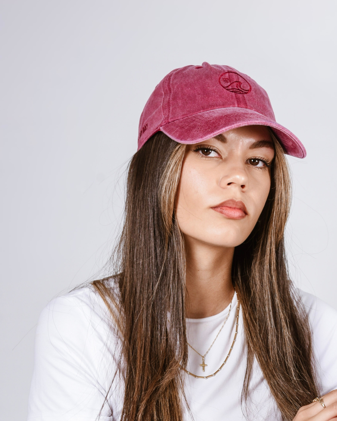 Woman wearing a red-pink cap against a white background