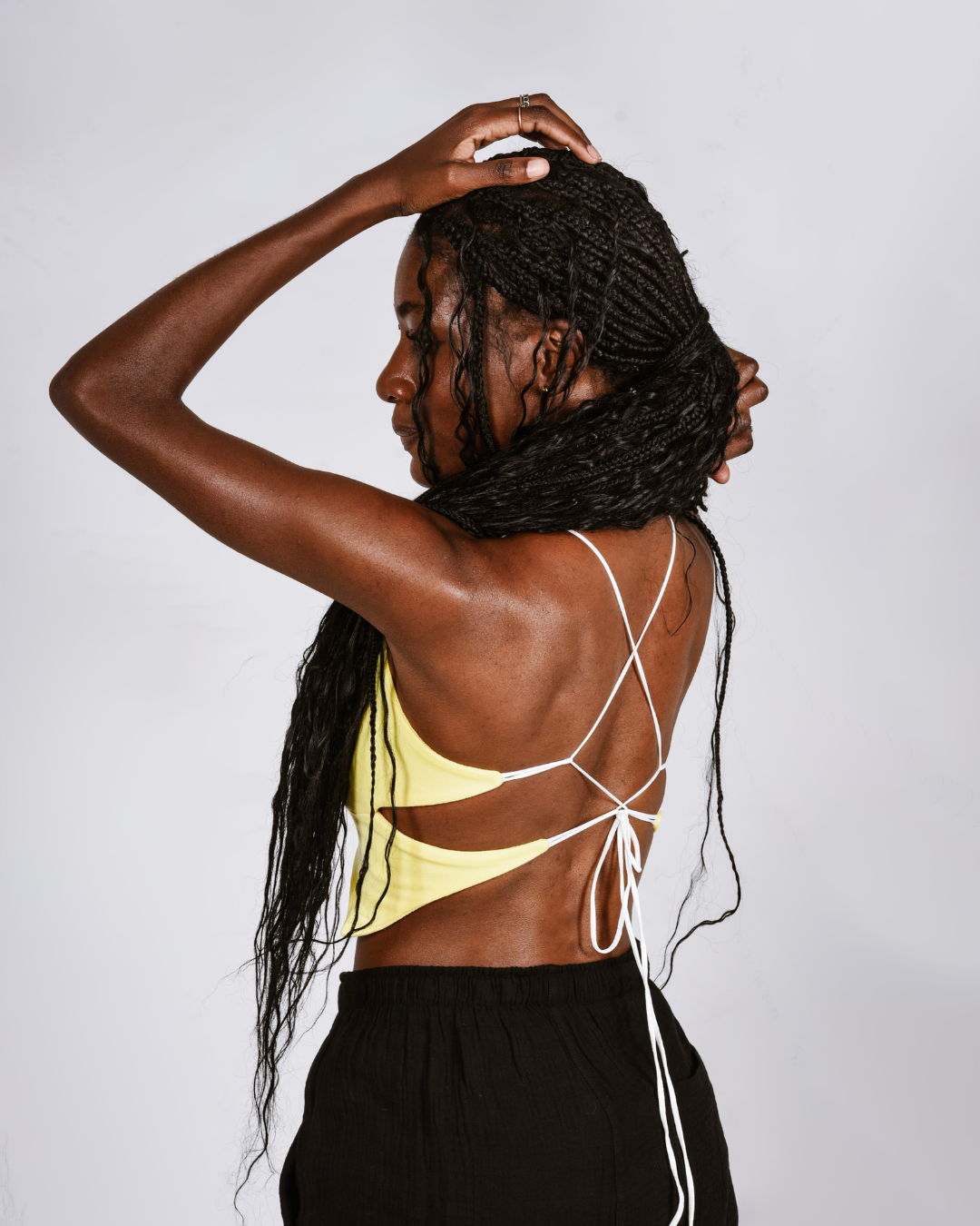 Woman wearing a yellow butterfly shaped top that ties at the back