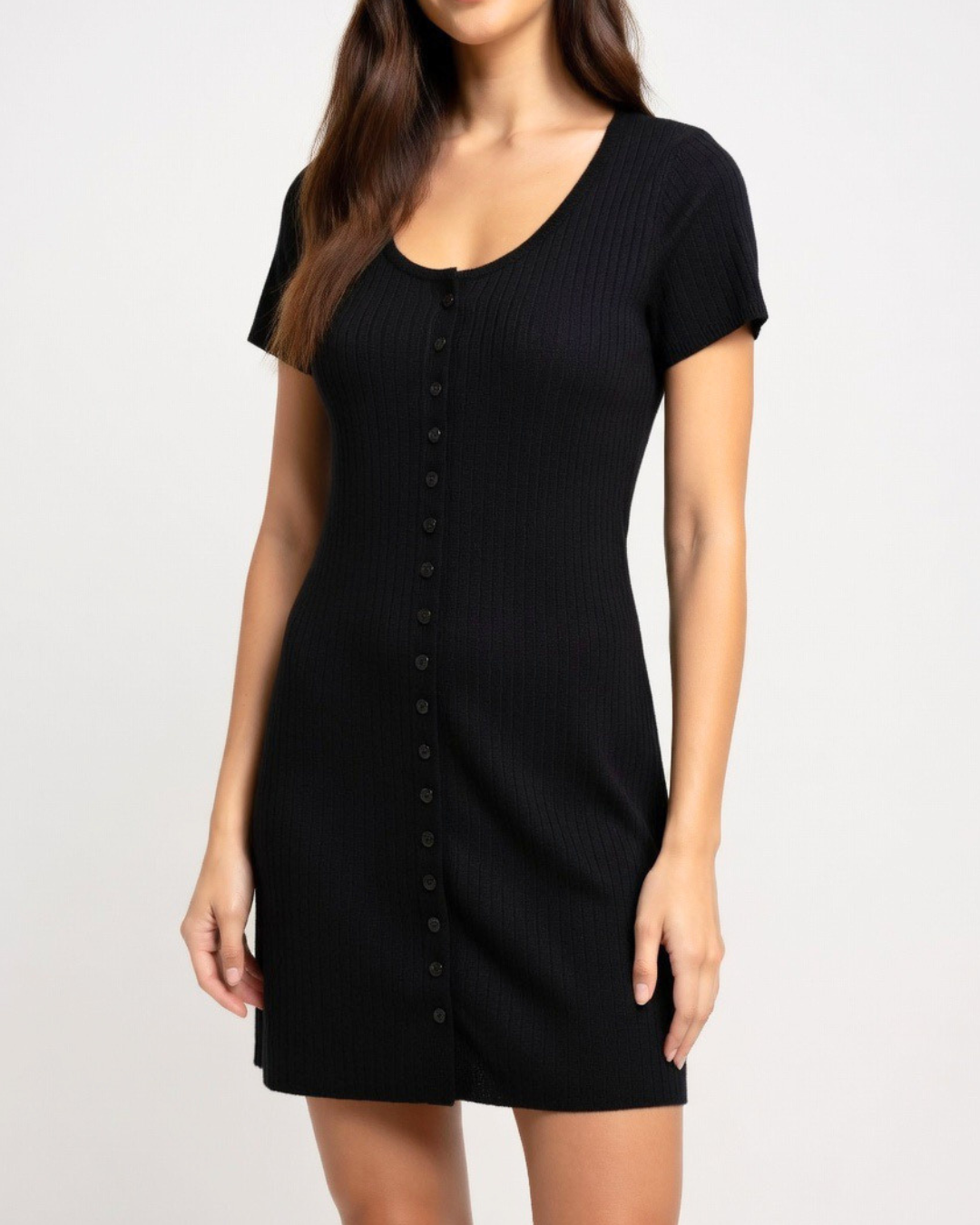 Woman wearing a black button up knit dress against a plain background