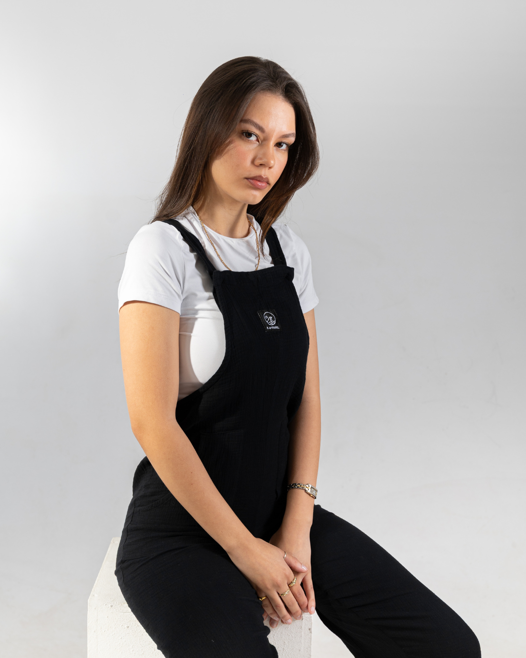 Female wearing a black cotton dungaree in studio