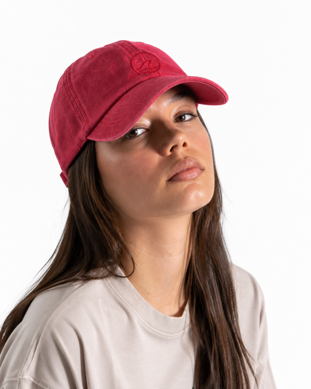 Female wearing a cherry red cap with the K-APPAREL logo on the front 