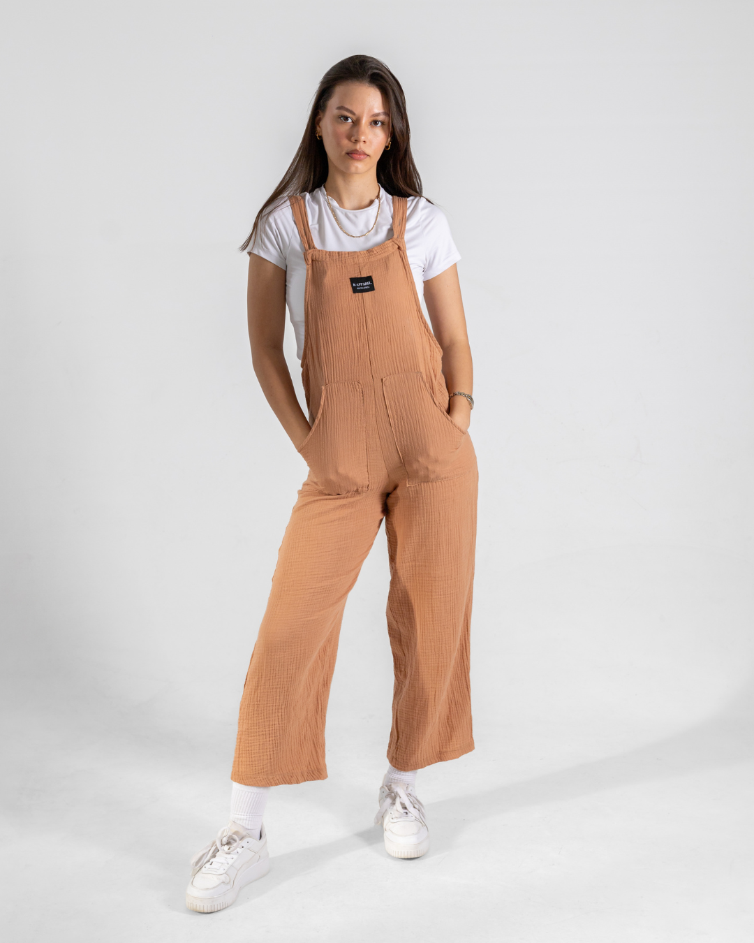 Female wearing coral dungarees in studio