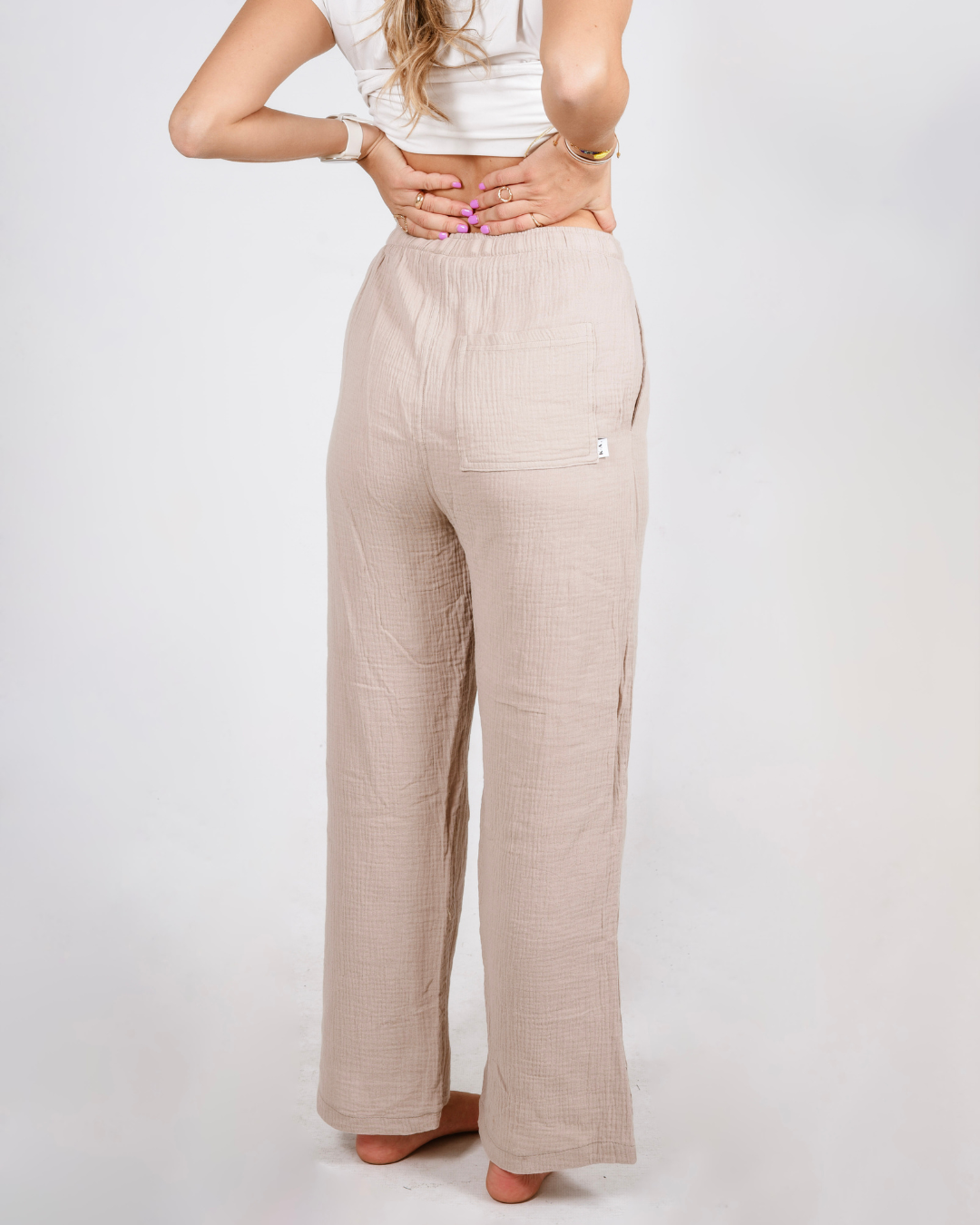 female wearing a cream pair of cotton high waisted pants