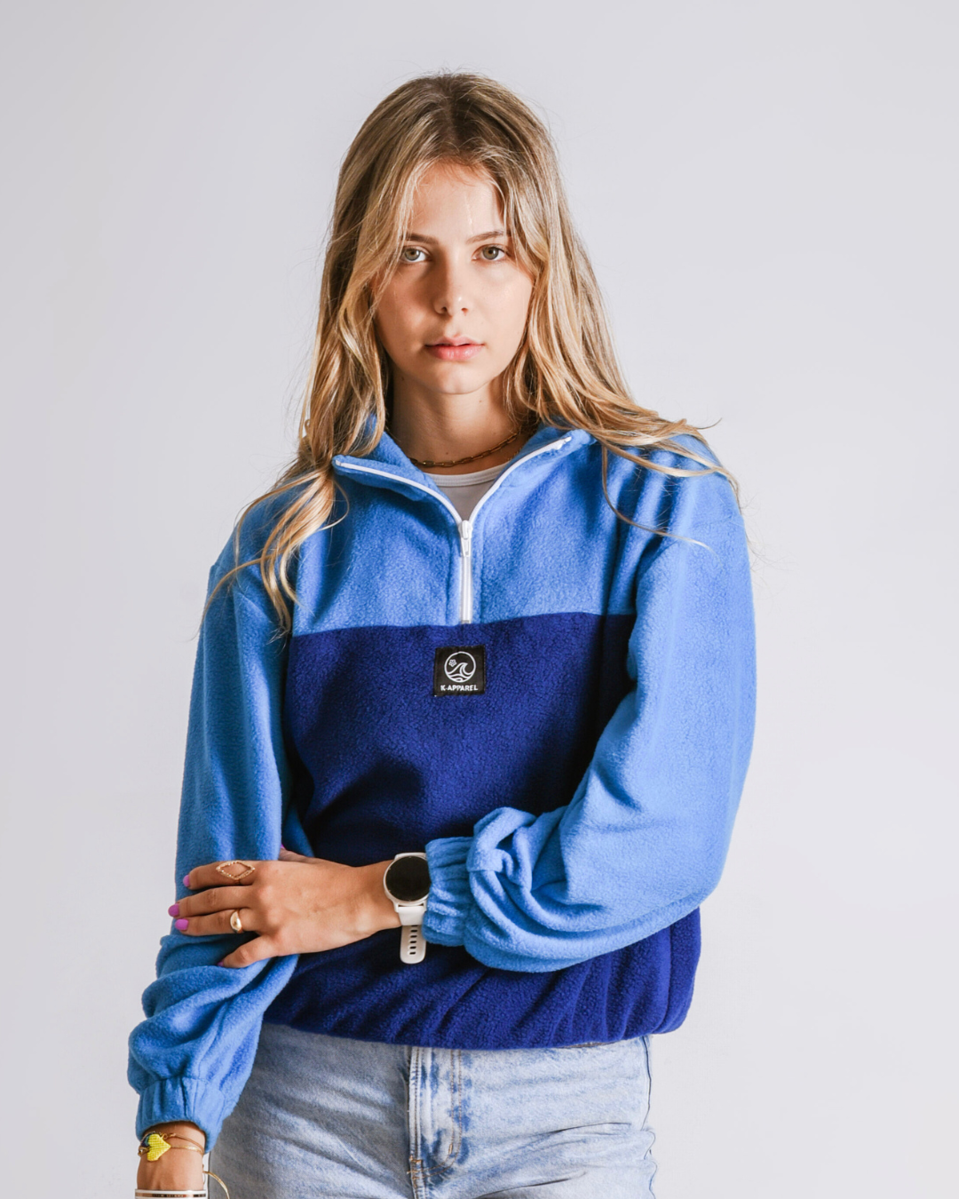 Female wearing a polar fleece quarter zip in the colour bottle blue and navy 