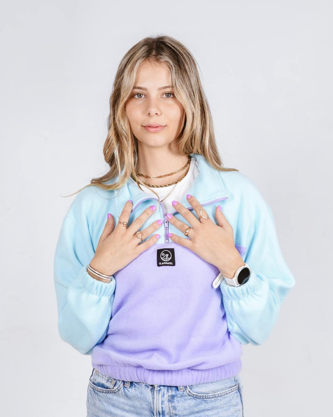 Female wearing a OG quarter zip retro jerseyin the colour purple and teal. 