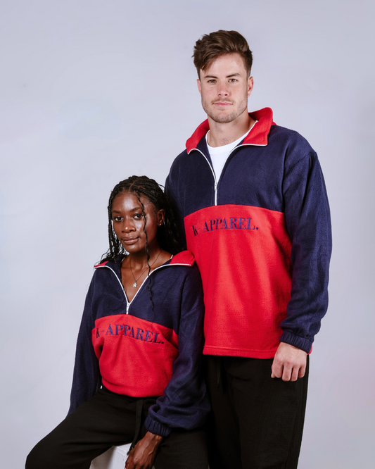 Two people wearing matching red and navy blue retro quarter zip jersey with 'Kapparel' branding on a white background.