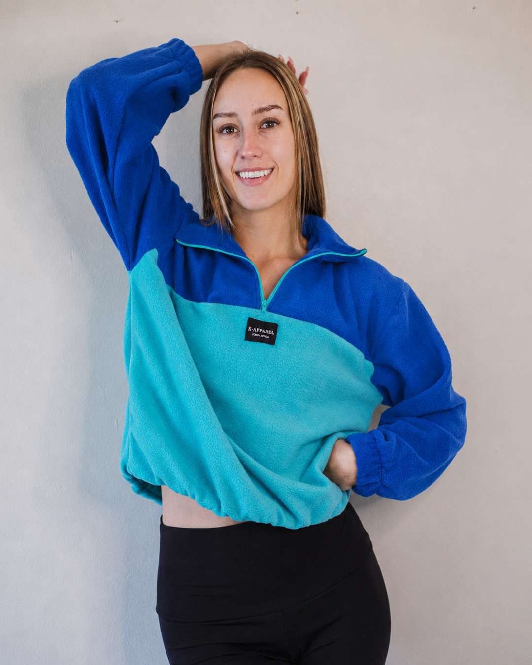 Female wearing a blue and teal polar fleece quarterzip