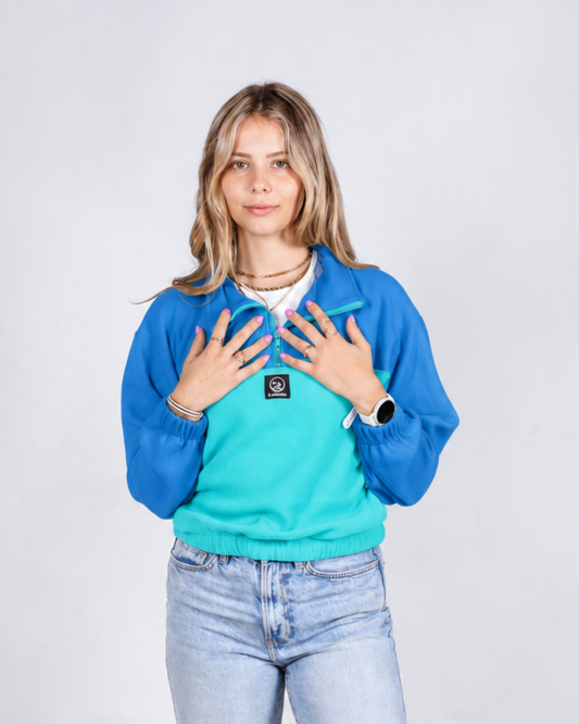 Female wearing a teal/ blue retro jersey in studio