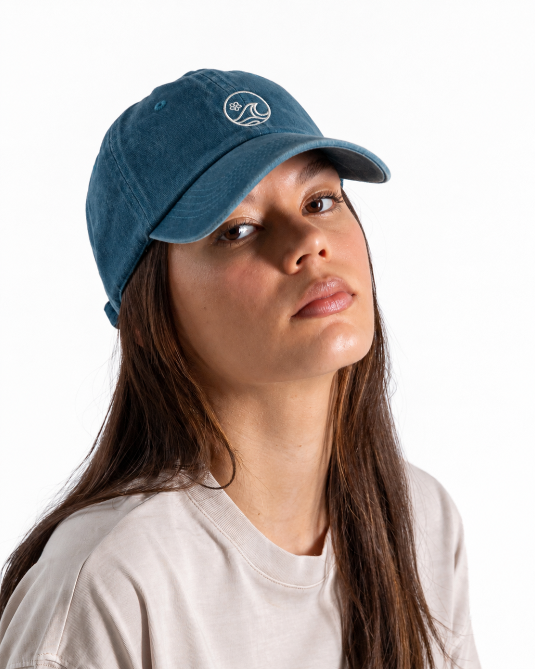 Female wearing a teal cap with a white K-APPAREL log on the front