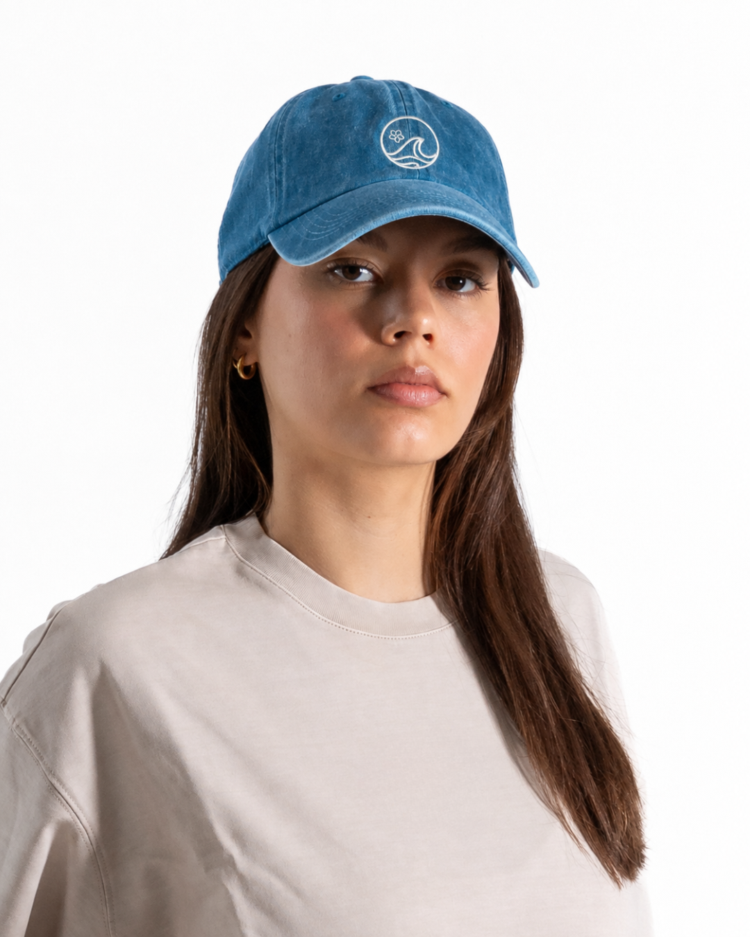 Female wearing a blue cap with a white logo on the front 