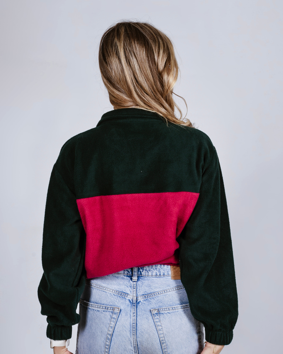 female wearing a maroon and green quarter zip  fleece jersey 