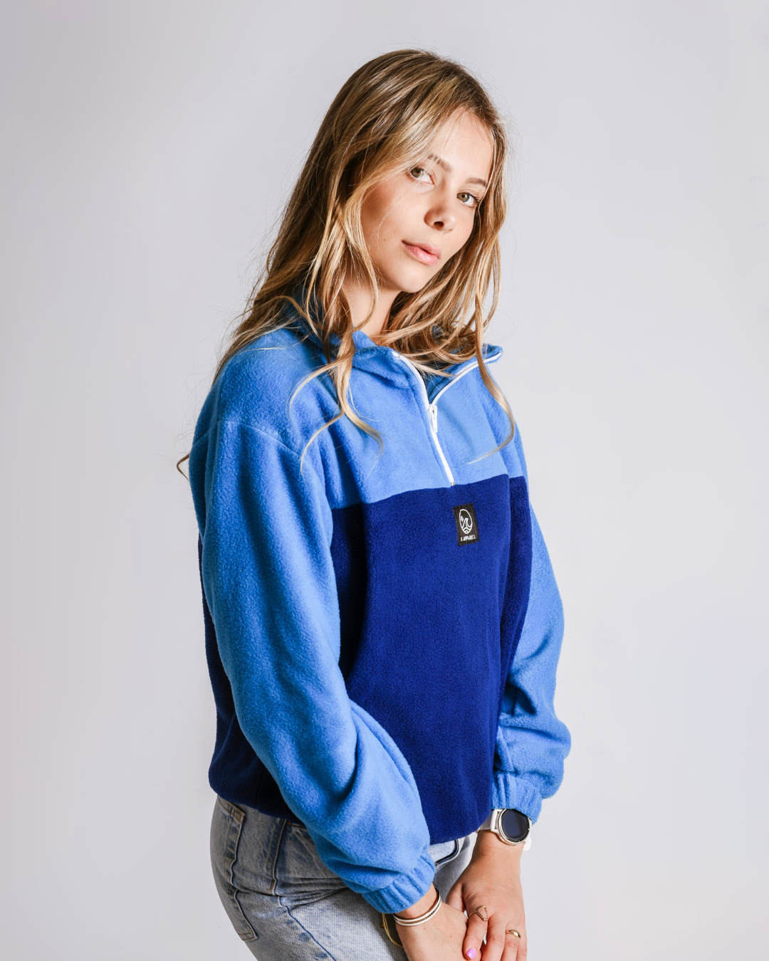 Female wearing a polar fleece quarter zip in the colour bottle blue and navy 