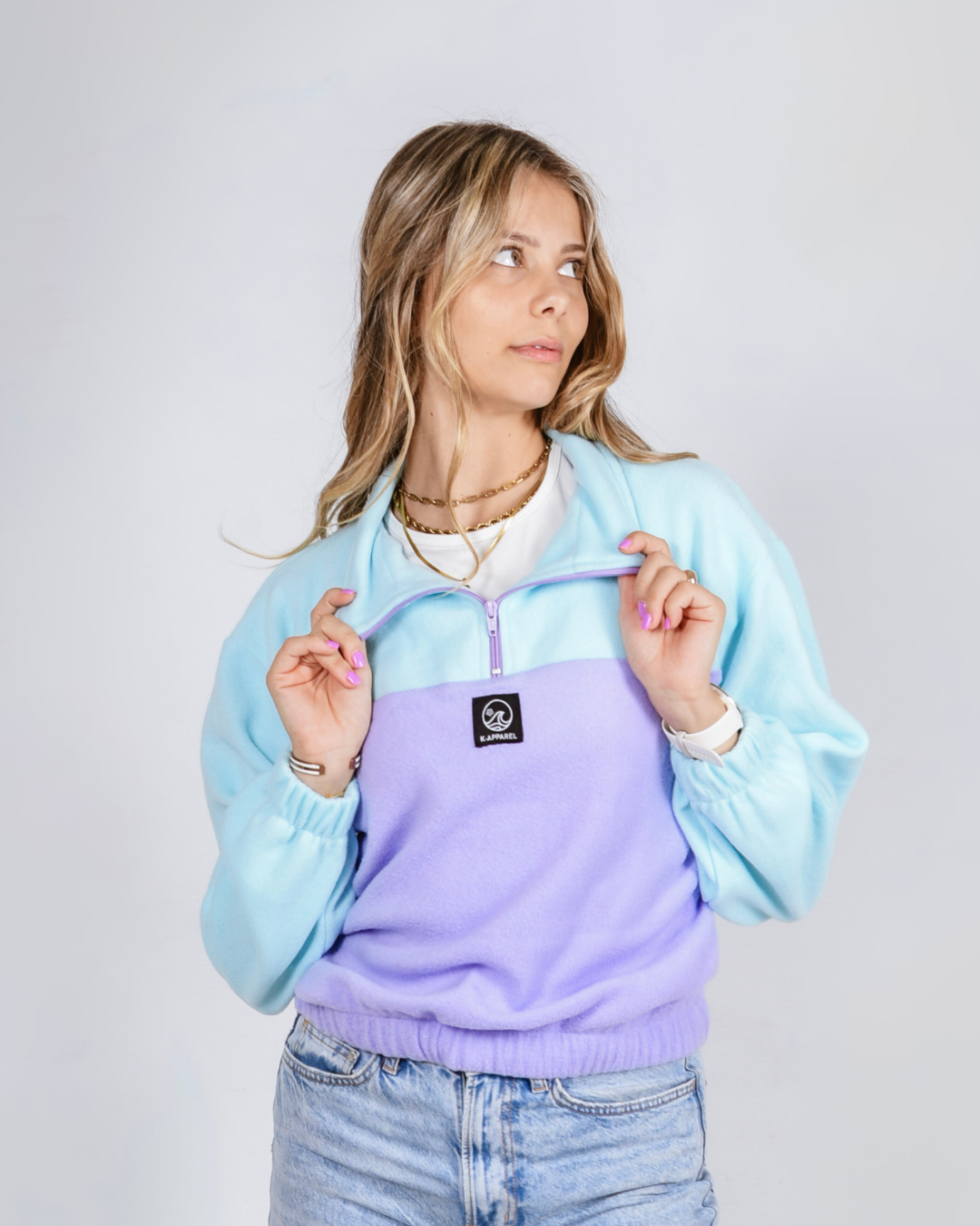 Female wearing a polar fleece quarter zip in the colour purple and teal. 
